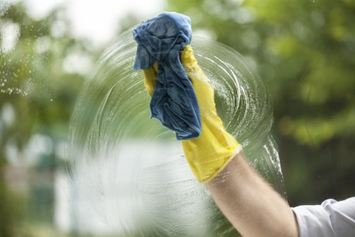 Cleaner wiping shared entrance surfaces in a local apartment building